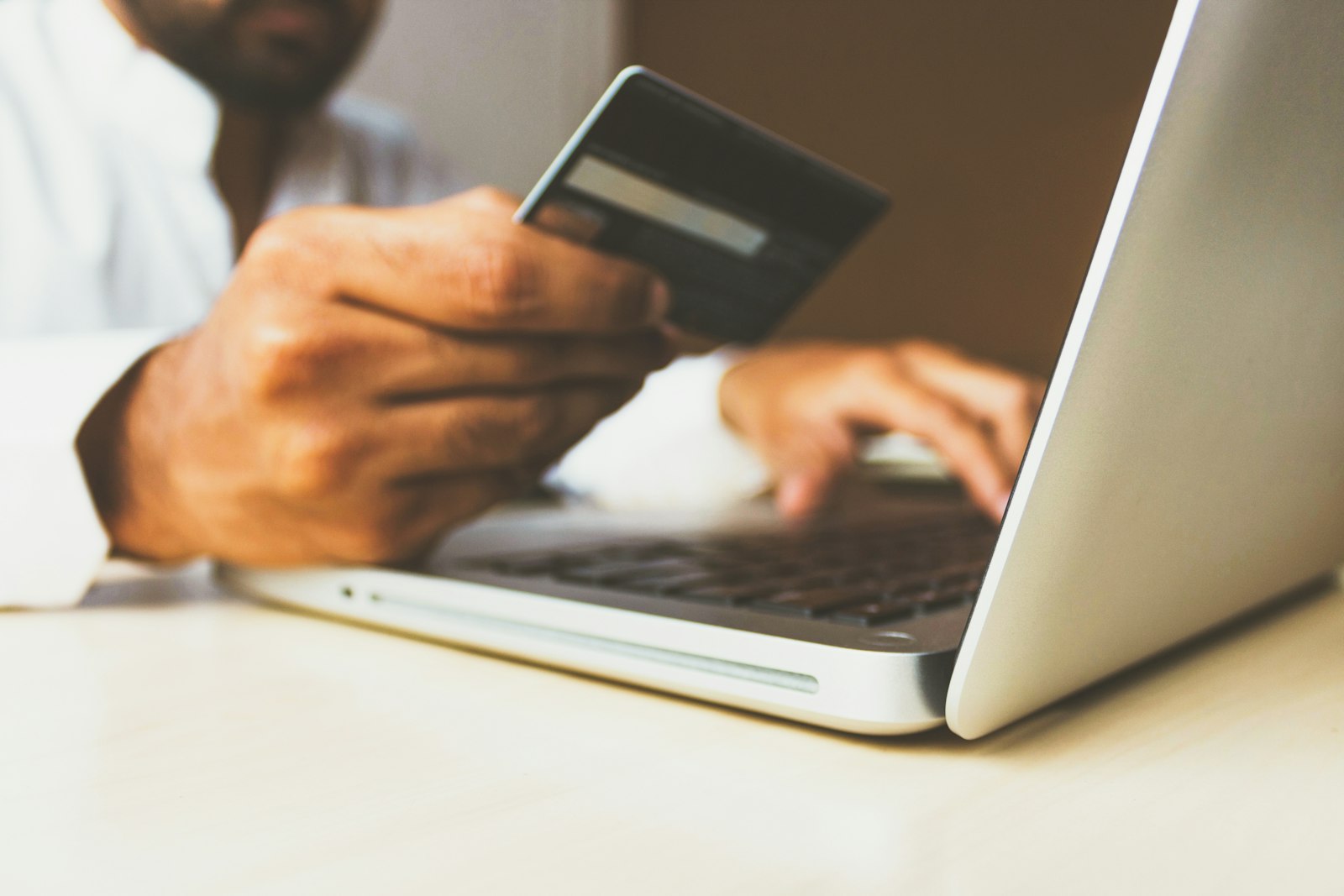 A customer entering card details on a laptop to complete an online purchase