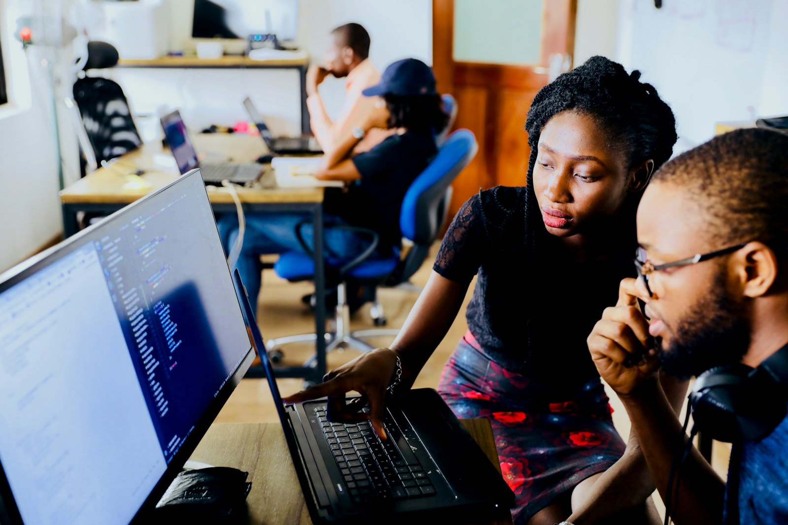 A trainer guiding a student through code on a laptop during a one-to-one session